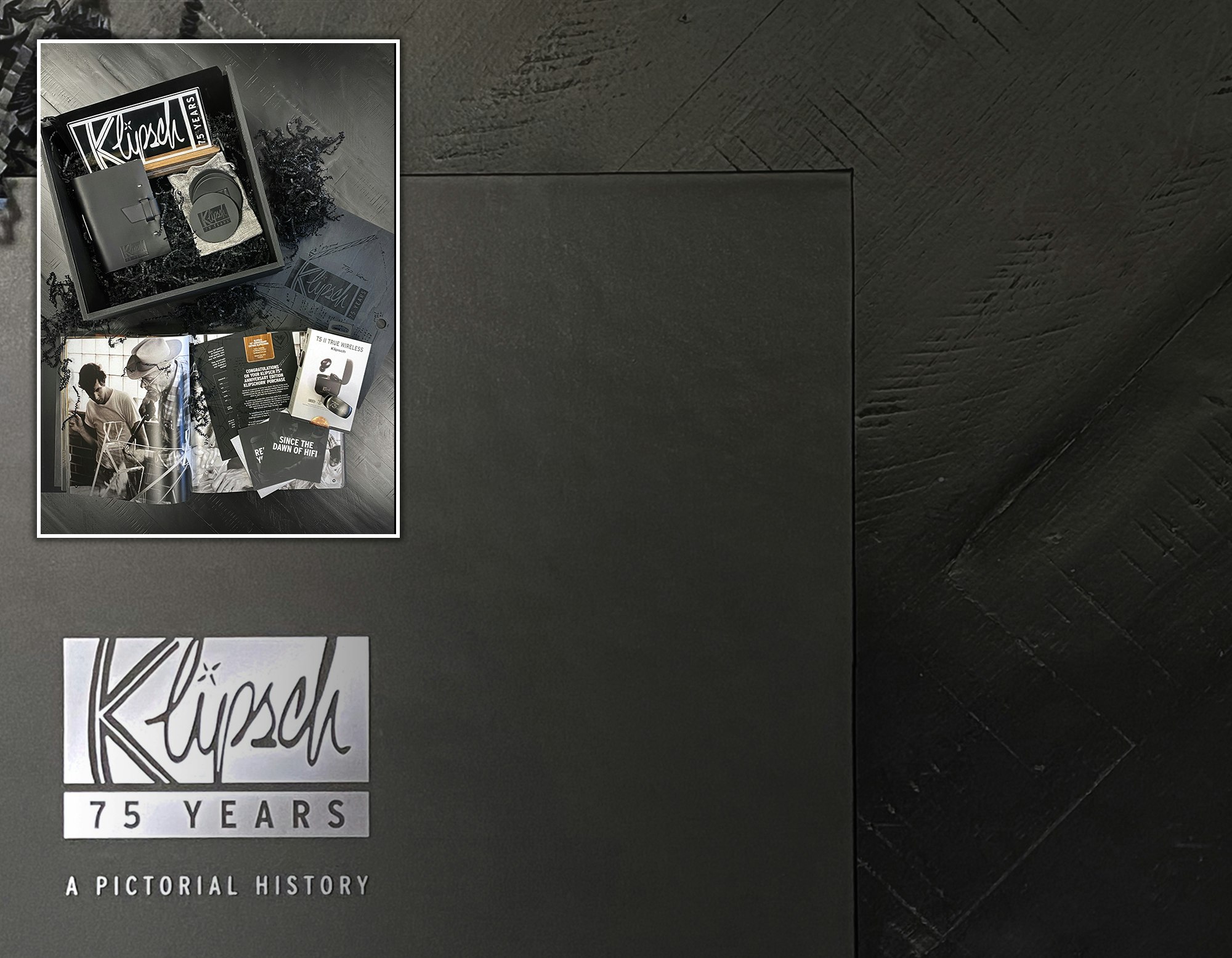 Image of additional items included with the 75th Anniversary Edition Klipsch Heritage Speakers including the 75 Years Pictorial History book a pair of T5 II True Wireless headphones and more